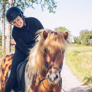 Ryttare klappar om sin häst från hästryggen.